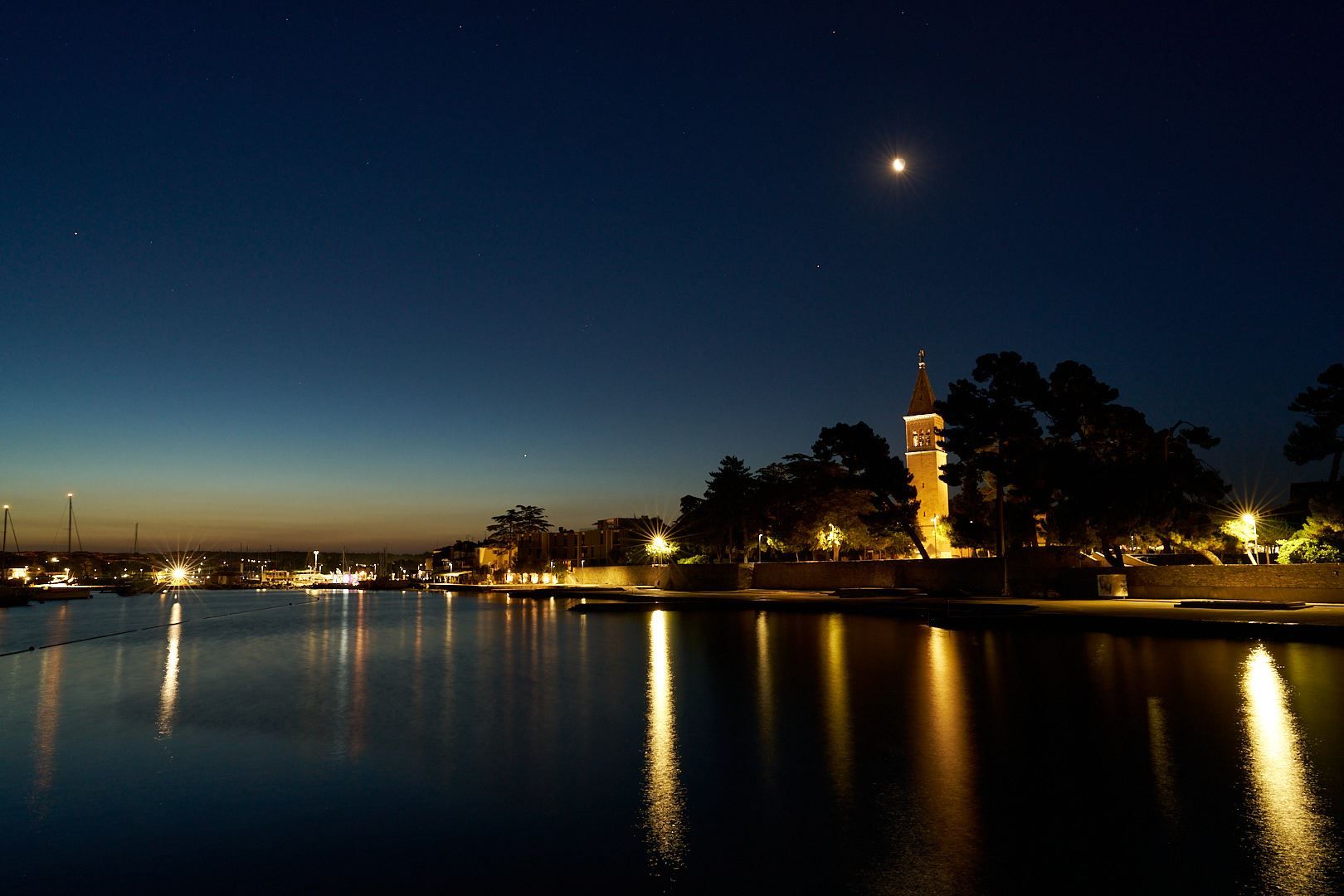 Der Mond über der Kirche St. Pelagius, der das Meer im Hafenbecken von Novigrad beleuchtet.