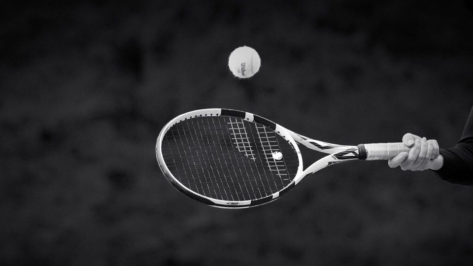 Ein Tennisschlägers der den Ball trifft.